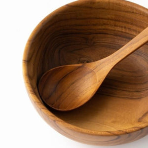 A close-up top-down view of a handcrafted teak wood soup spoon resting inside a matching solid teak bowl, showcasing the intricate natural wood grain and smooth, food-safe finish against a clean white background.