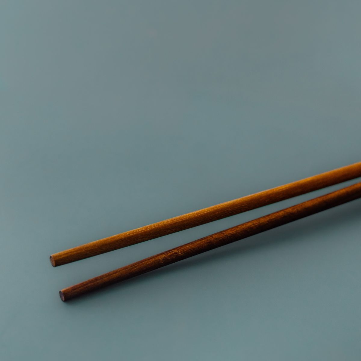 Close up of the ends of a pair of handcrafted wooden cooking chopsticks
