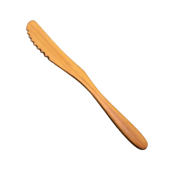 A handcrafted serrated knife made from solid teak wood, featuring a naturally sharp notched edge and a smooth ergonomic handle, ideal for slicing soft breads, cakes, or cheeses without sticking.