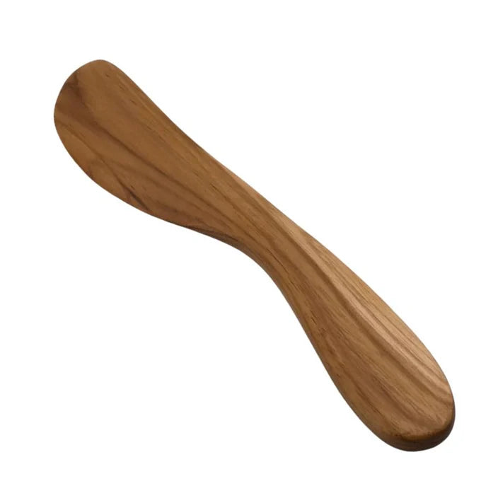 A single, hand-carved spread knife made from solid teak wood, featuring an ergonomic curved handle and a broad, smooth blade ideal for serving soft cheeses, pates, and artisanal spreads.