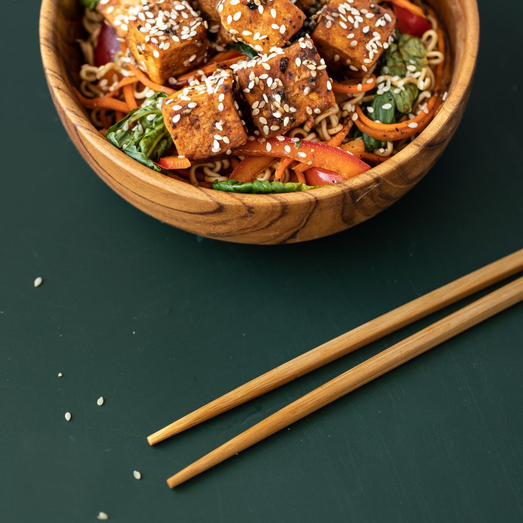 wooden chopsticks next to a bowl of food