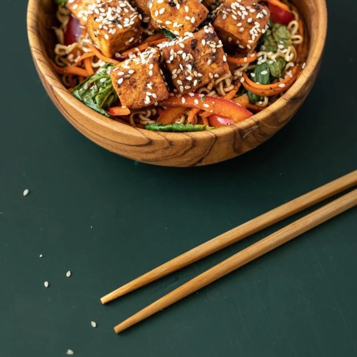 Handcrafted wooden chopsticks ready to be used to eat noodles in a bowl