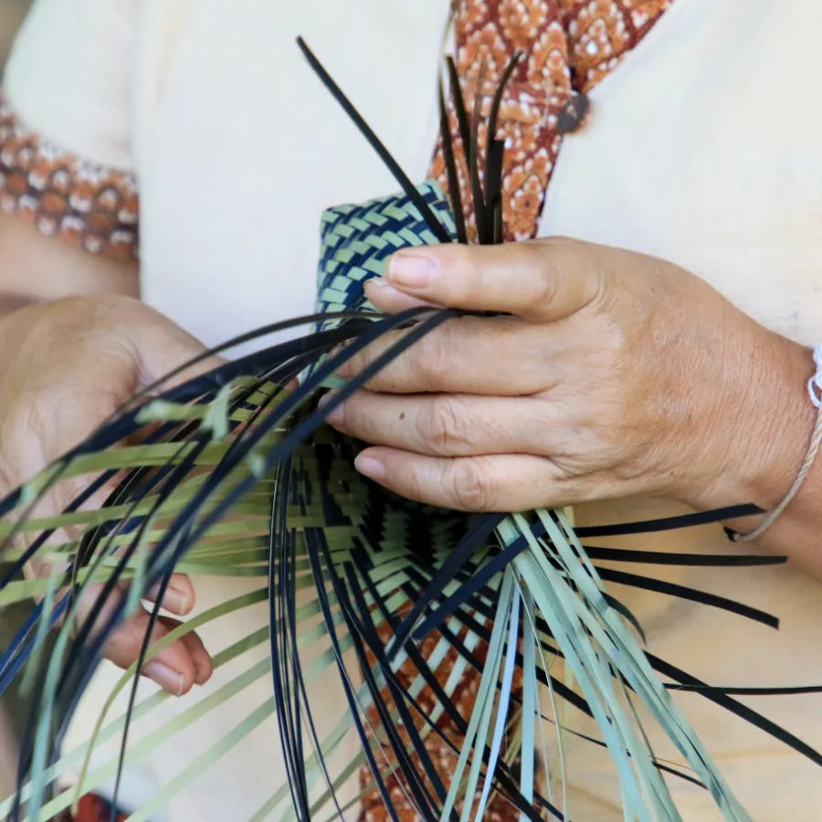 women hand weaving bags