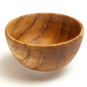 A product photograph of a small 8 cm handcrafted teak wood bowl, shown from a slightly elevated angle against a clean white background. Part of a non-toxic mealtime set for children, this bowl is carved from a single piece of sustainable teak, featuring a smooth, food-safe finish and rich natural grain. Its compact size is specifically designed for small toddler portions, such as snacks or first foods, providing a durable and plastic-free alternative for early childhood dining.