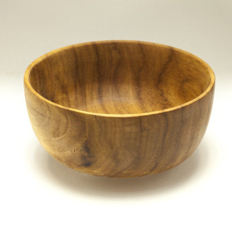 A handcrafted 13 cm teak wood bowl shown from a slightly elevated angle against a clean white background. The bowl features deep, rounded sides and a beautiful, natural grain with rich golden-brown and chestnut tones. Carved from a single piece of premium, sustainable teak, it has a smooth, food-safe finish, making it a safe, non-toxic, and durable choice for children's meals, snacks, or cereal.
