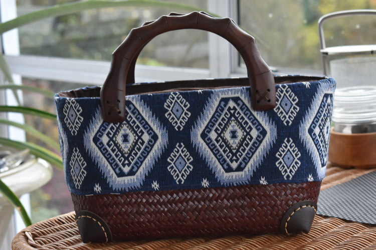 handwoven bag with blue design and wooden handles