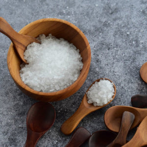 wooden salt spoon in wooden bowl containig salt