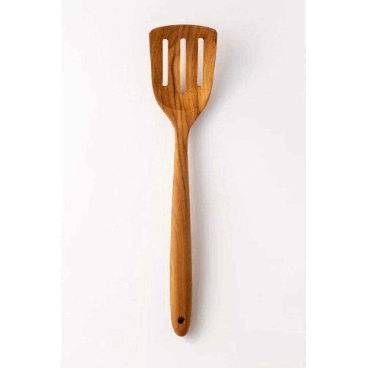 A handcrafted, premium teak wood slotted turner, also known as a fish slice, viewed head-on against a plain white background. The utensil features a wide, square head with three parallel vertical slots designed for efficient draining, a long ergonomic handle, and a functional hanging hole at the base. The detailed view emphasizes the rich, natural wood grain pattern and smooth polished finish, showcasing it as a durable, non-scratch tool ideal for flipping delicate foods like fish and eggs in non-stick cook